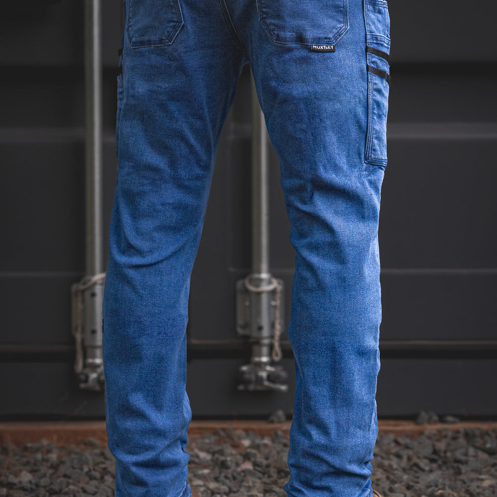 Rear angle of the RX-1 Relaxed Work Jeans in Stonewashed Blue, showcasing the dual thigh pockets and classic fit designed for durability and flexibility on-site.