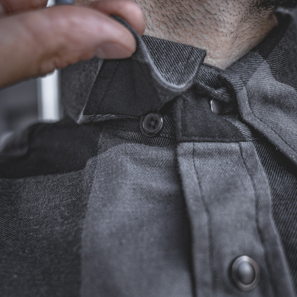 
                  
                    Close-up of the Huxtley HD-57 Flex Flannel in Charcoal/Black, featuring a hidden collar button to keep your shirt looking sharp and locked in, no matter how hard the day hits.
                  
                