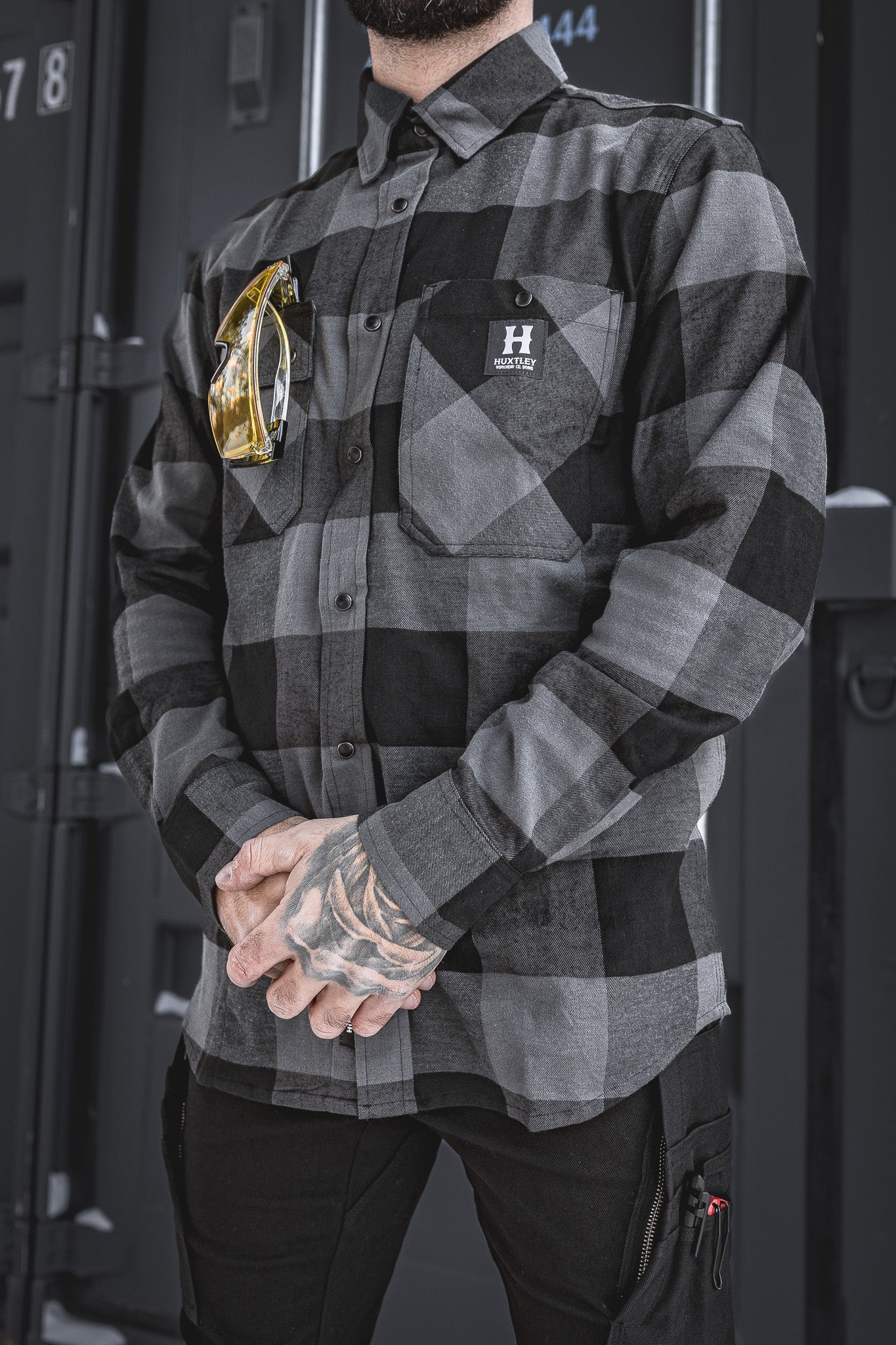 
                  
                    The Huxtley HD-57 Flex Flannel in Charcoal/Black delivers a durable, stretch-built fit with work-ready storage and style. Shown here with safety glasses tucked into the chest pocket—this flannel’s made for the grind.
                  
                