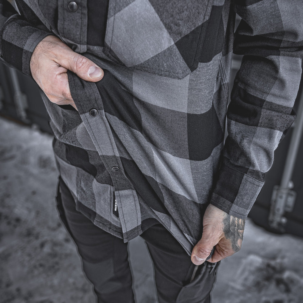 Close-up of the Huxtley HD-57 Flex Flannel in Charcoal/Black, showing off its built-in stretch for easy movement and jobsite mobility. This flannel works as hard as you do—no compromises on comfort or toughness.