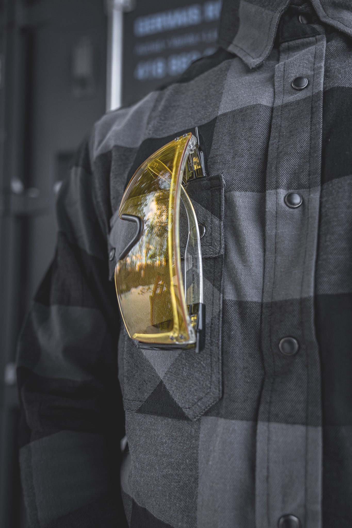 
                  
                    Detail of the Huxtley HD-57 Flex Flannel in Charcoal/Black, featuring a chest pocket perfectly sized for safety glasses or small gear. Designed for tradesmen who need function and durability on the go.
                  
                