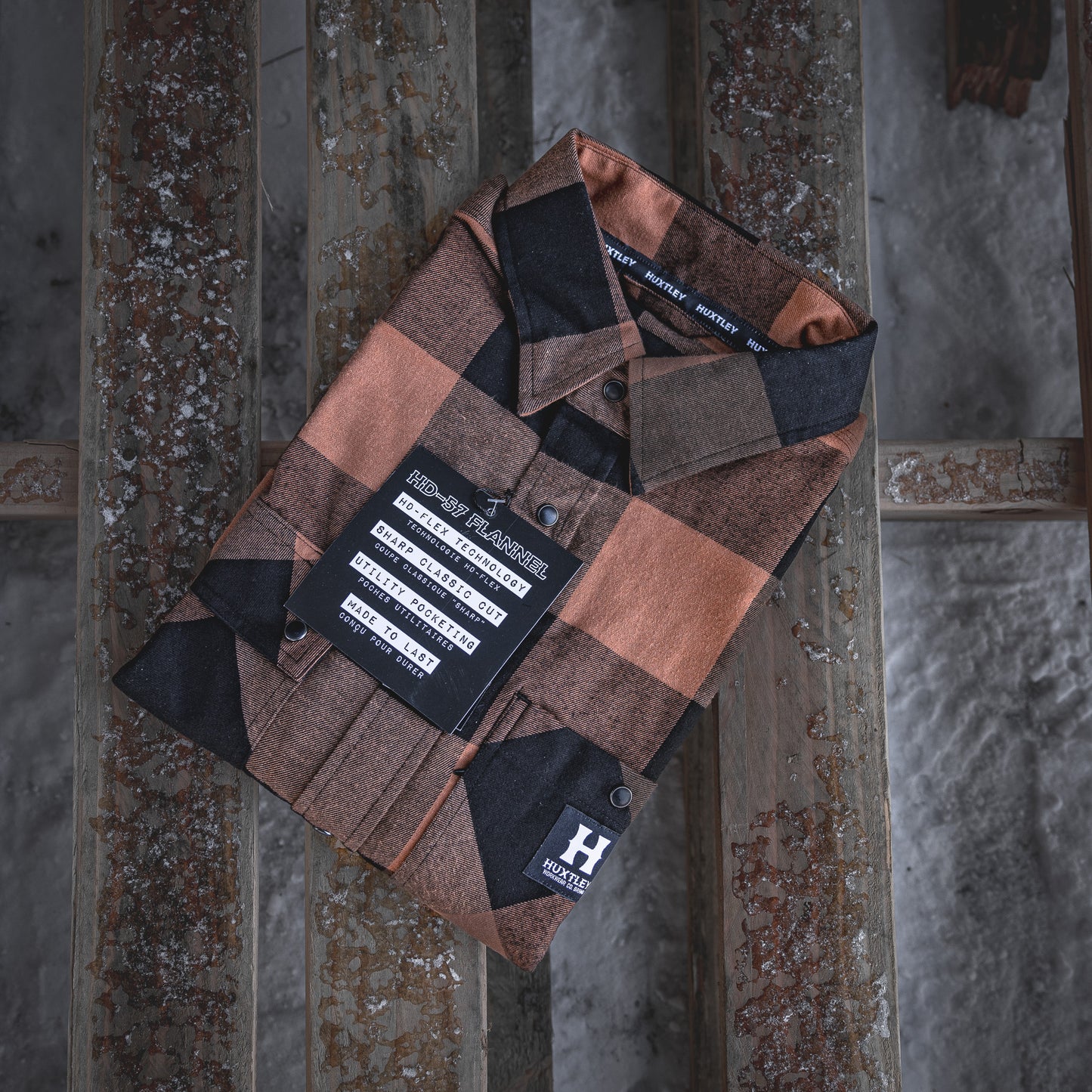 
                  
                    Folded display of the Huxtley HD-57 Flex Flannel in Whiskey/Black, highlighting key features like HD-Flex technology, sharper tailoring, and utility pocketing. Built for tradesmen, packed with purpose.
                  
                