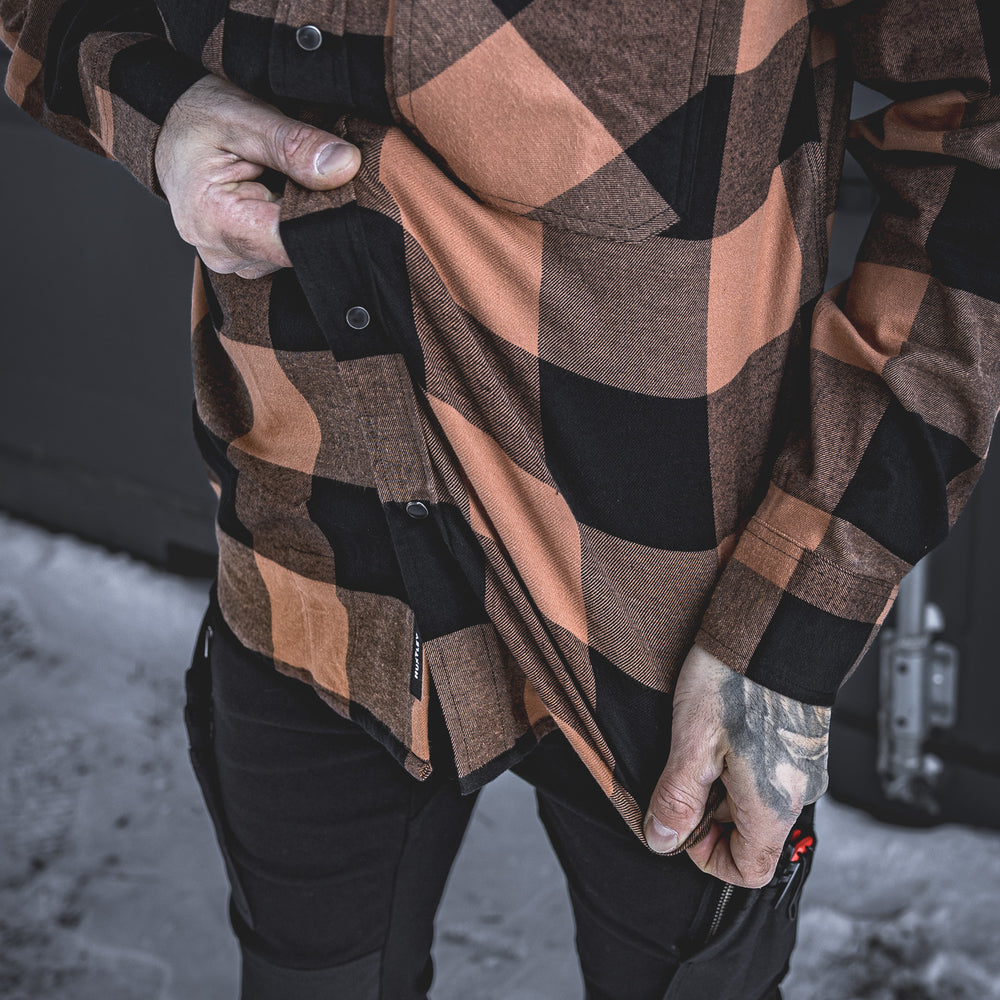 Close-up of the Huxtley HD-57 Flex Flannel in Whiskey/Black, highlighting its built-in stretch for maximum comfort and mobility. Perfect for tough jobs and long days, this flannel flexes when you do without sacrificing durability.