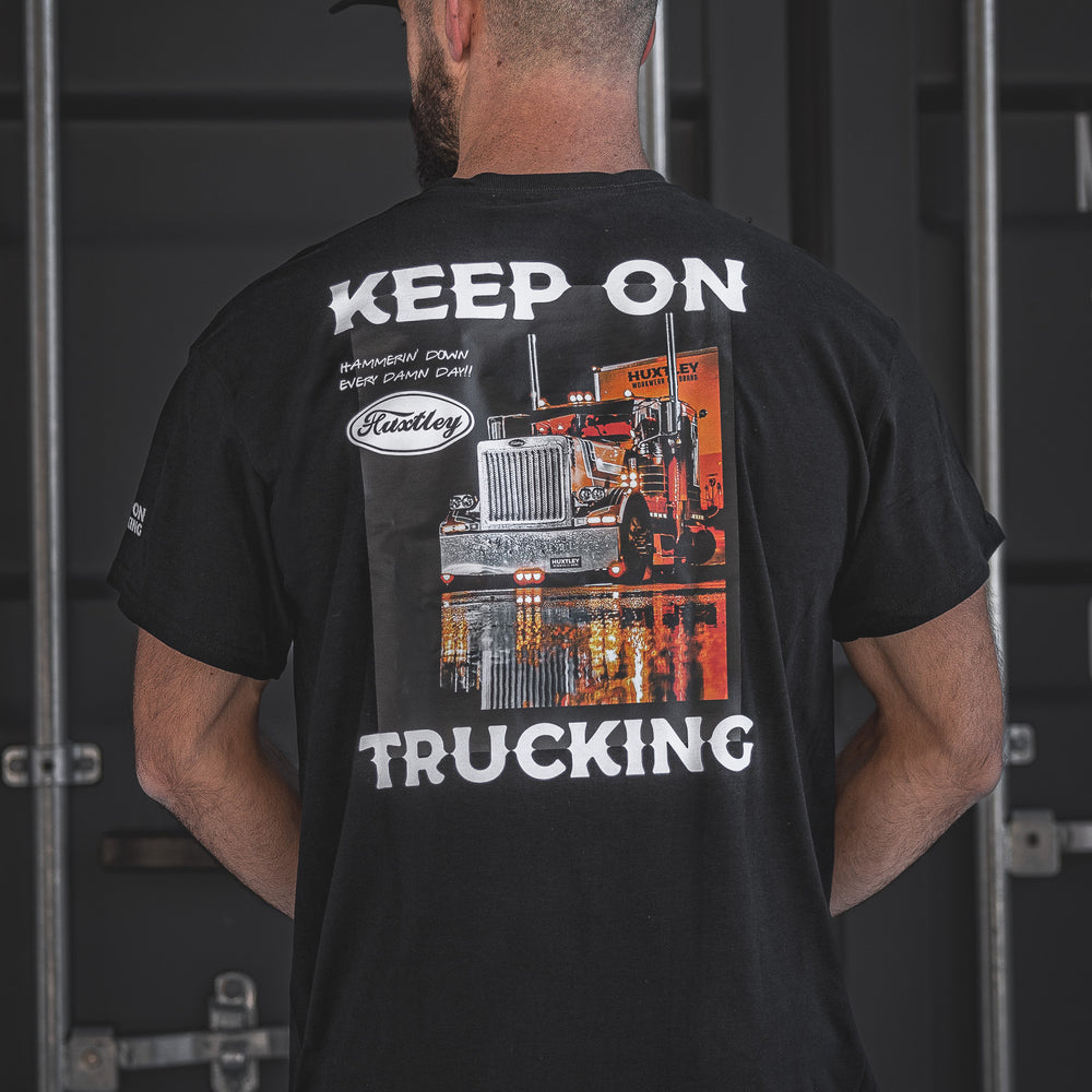 The Huxtley “Keep On Trucking” tee in black features a bold big rig graphic with the motto “Hammerin’ Down Every Damn Day!” Made for hard-working haulers and highway legends who never lift off the throttle.