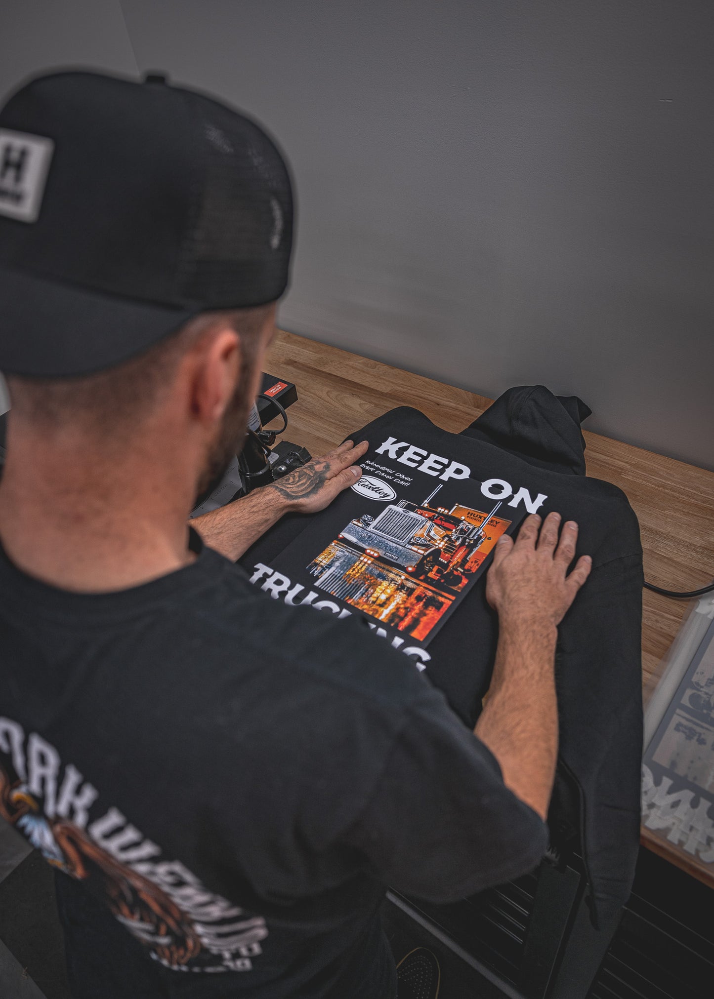 
                  
                    Behind-the-scenes look at the Huxtley Keep On Trucking Hoodie in production. Featuring the iconic big rig graphic and bold lettering, this piece brings serious heat to the shop floor and the open road.
                  
                