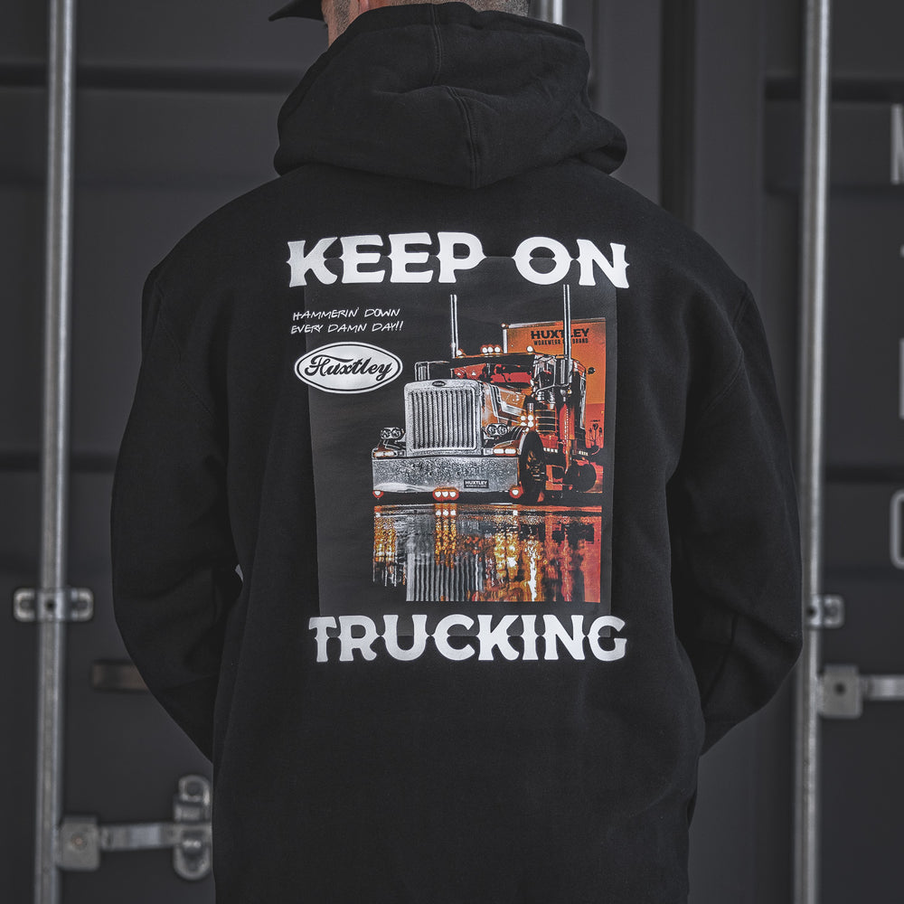 Back view of the Huxtley Keep On Trucking hoodie in black. Featuring a bold semi-truck print and “Hammerin’ Down Every Damn Day!!” motto—made for long hauls and cold yards.