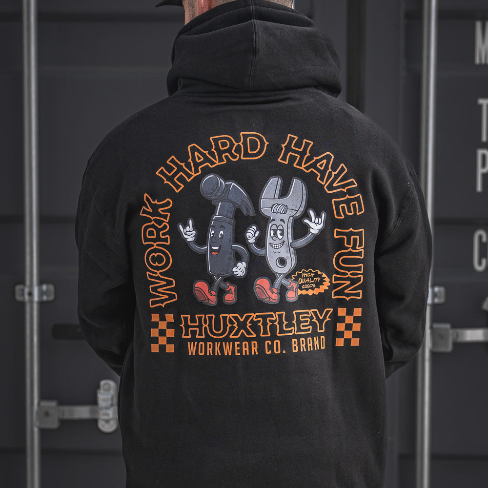 Grind hard, smile harder in the Huxtley Work Hard Have Fun Hoodie. This black hoodie features bold orange print and a fun cartoon hammer-and-wrench duo, built for jobsite jokers who don’t take life too seriously.