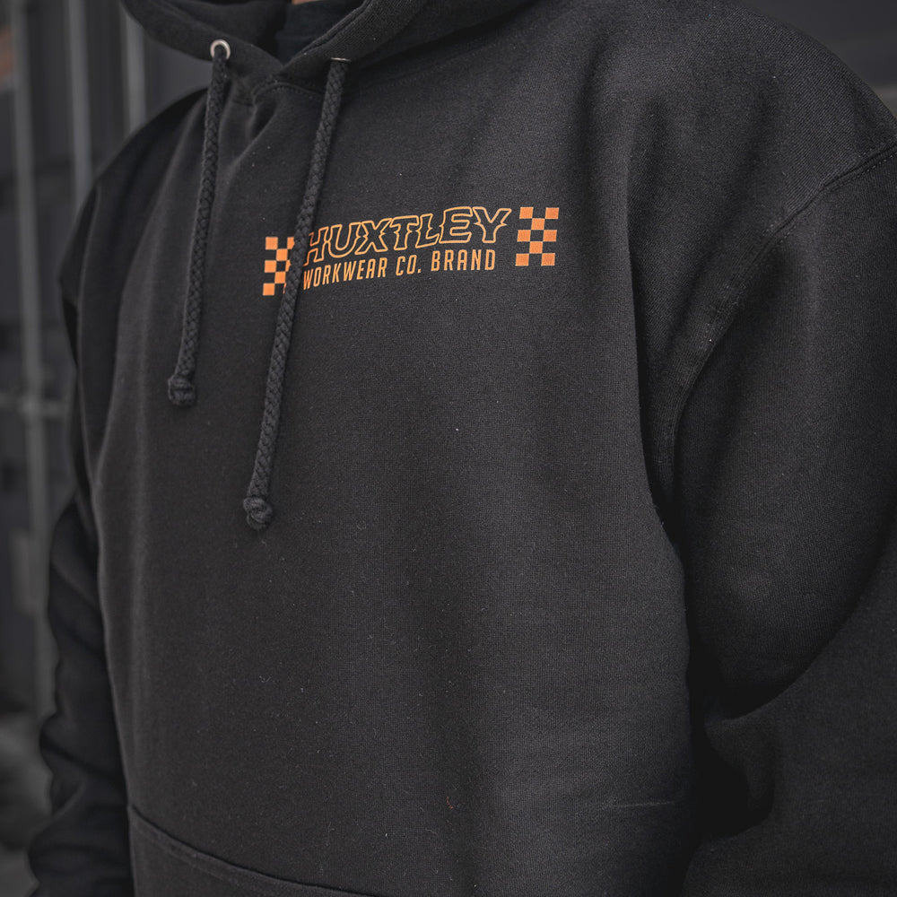
                  
                    Detailed view of the Huxtley Work Hard Have Fun Hoodie, spotlighting the orange checkerboard chest logo. Built for the trades, styled for the street—this one’s all about hard work and good times.
                  
                