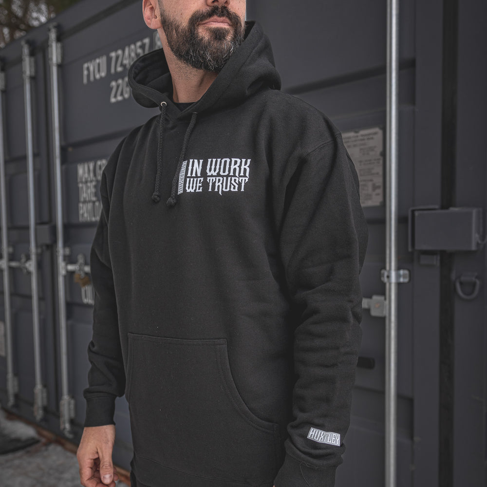 
                  
                    Model wearing the In Work We Trust Hoodie in black. Gothic chest print, relaxed fit, and branded sleeve tag. Built for grit, styled for the site.
                  
                