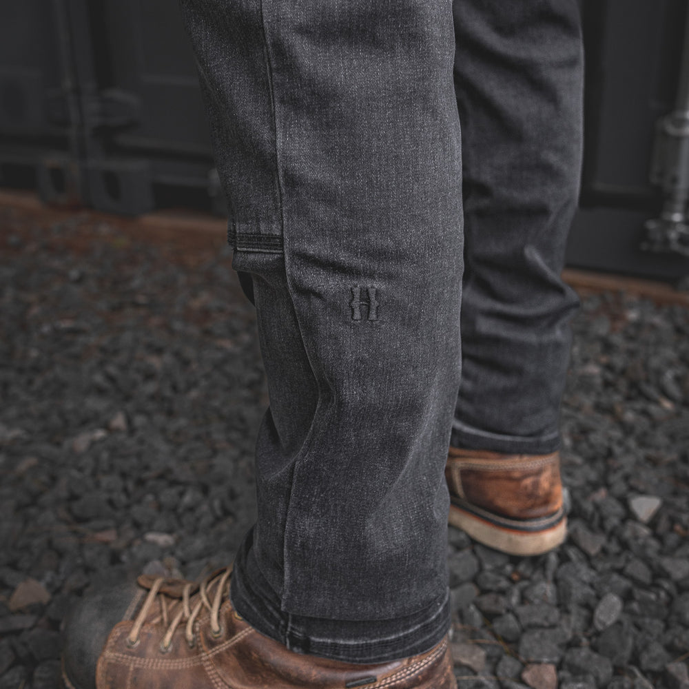 
                  
                    Close-up of the RX-1 Relaxed Work Jeans in Stonewashed Black showcasing the tonal embroidered Huxley “H” on the lower leg, built for style and strength on site.
                  
                