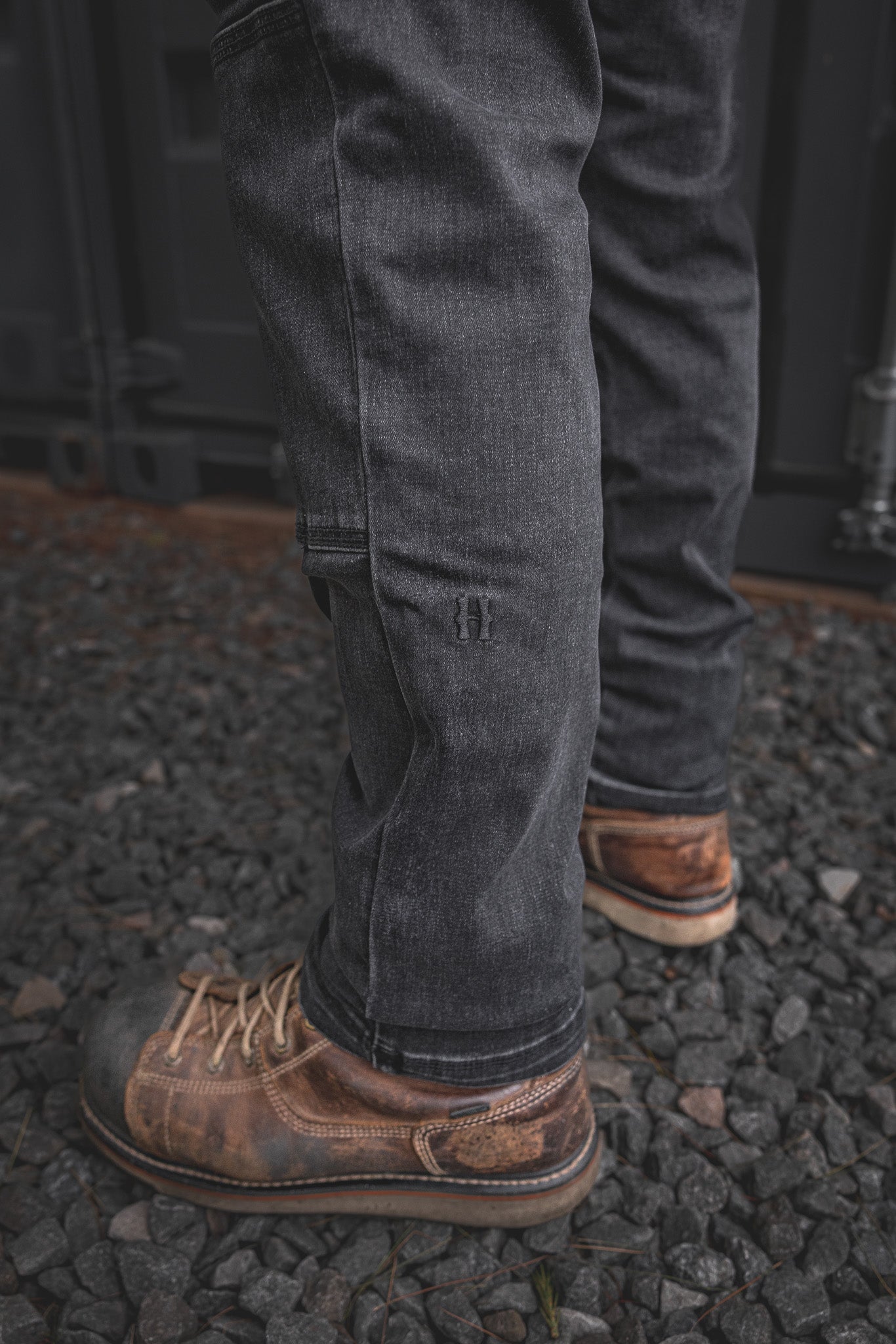 
                  
                    Close-up of the RX-1 Relaxed Work Jeans in Stonewashed Black showcasing the tonal embroidered Huxley “H” on the lower leg, built for style and strength on site.
                  
                