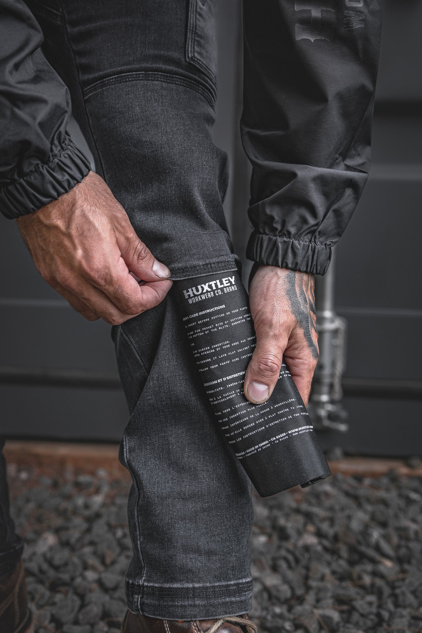 
                  
                    The RX-1 Relaxed Work Jeans in Stonewashed Black shown with a kneepad being inserted into the dedicated knee slot. Engineered for jobsite protection and all-day durability.
                  
                