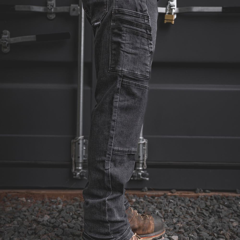
                  
                    Side view of the RX-1 Relaxed Work Jeans in Stonewashed Black, featuring stacked utility pockets and articulated knees for everyday worksite performance.
                  
                