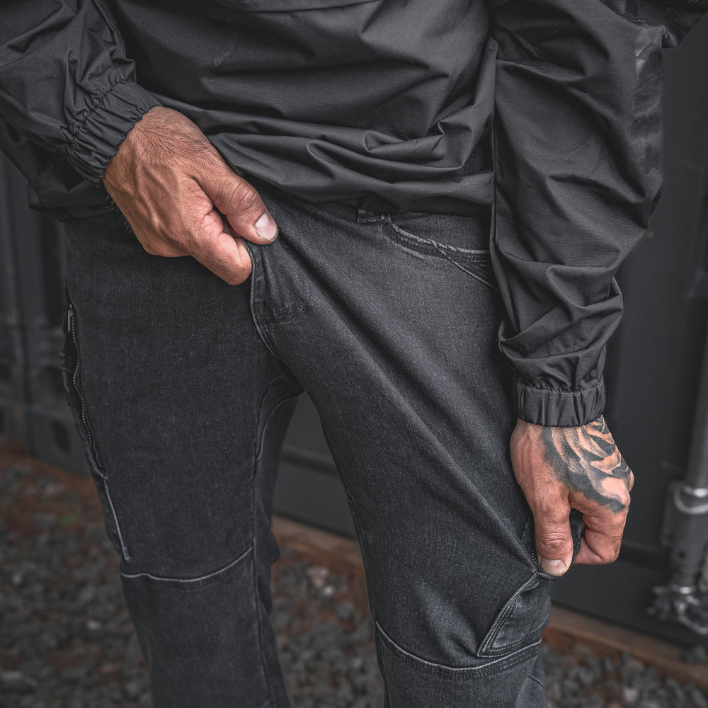 
                  
                    Close-up of the RX-1 Relaxed Work Jeans in Stonewashed Black showing the built-in stretch fabric. Designed for trades who bend, squat, and move all day.
                  
                