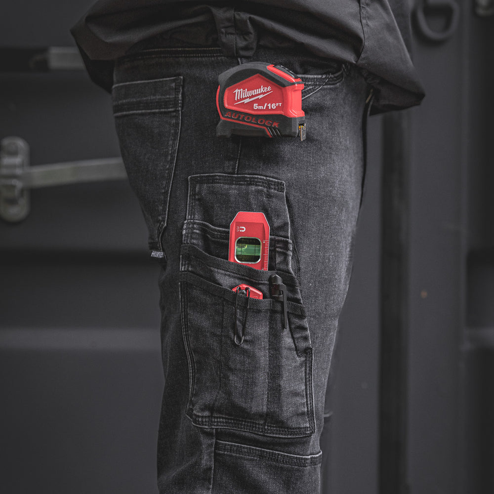 
                  
                    The RX-1 Relaxed Work Jeans in Stonewashed Black shown with a tape measure, laser level, and utility knife stored in the tool pocket. Built for practical on-site use and pro-level convenience.
                  
                