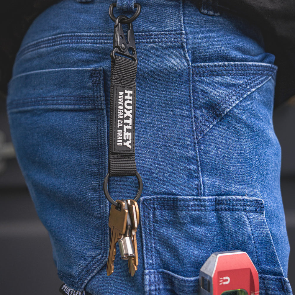 
                  
                    RX-1 Relaxed Work Jeans in Stonewashed Blue shown with lanyard hook in action—perfect for keeping keys, badges, or tags secure on-site while staying hands-free.
                  
                
