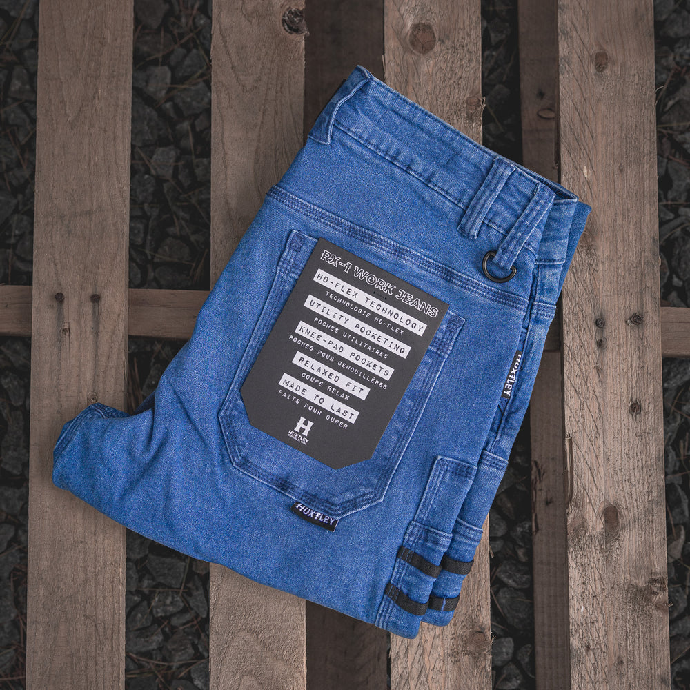 
                  
                    RX-1 Relaxed Work Jeans in Stonewashed Blue, neatly folded to reveal the back pocket and feature tag—showcasing HD-Flex stretch, knee pad pockets, utility loops, and all-day comfort construction.
                  
                