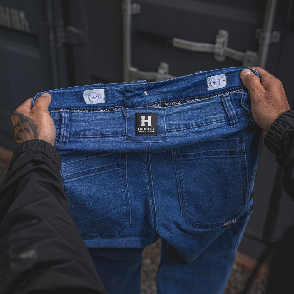 
                  
                    Close-up of the RX-1 Relaxed Work Jeans in Stonewashed Blue, highlighting the inside waistband and adjustable interior button tabs—engineered for all-day fit and durability on site.
                  
                