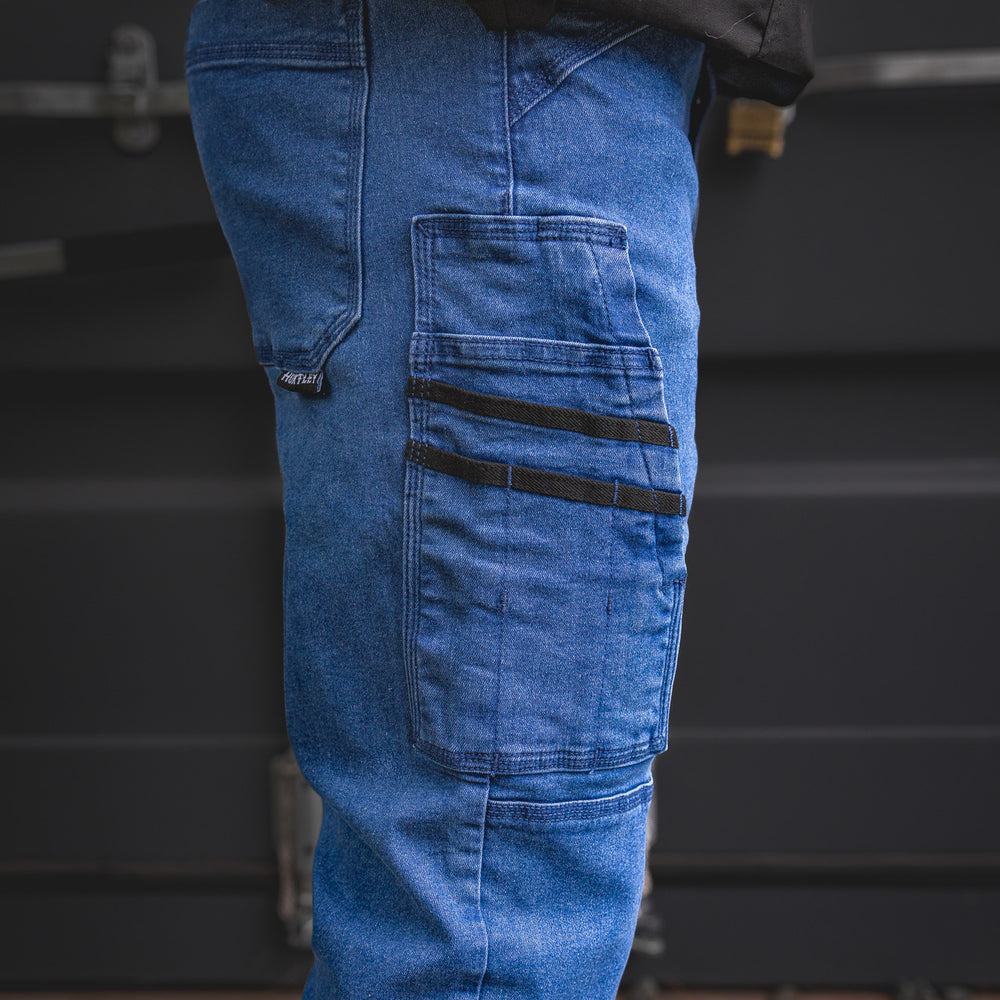 
                  
                    Zoomed-in detail of the RX-1 Relaxed Work Jeans in Stonewashed Blue, showing reinforced tool pocket design with black utility straps—engineered for performance on-site.
                  
                