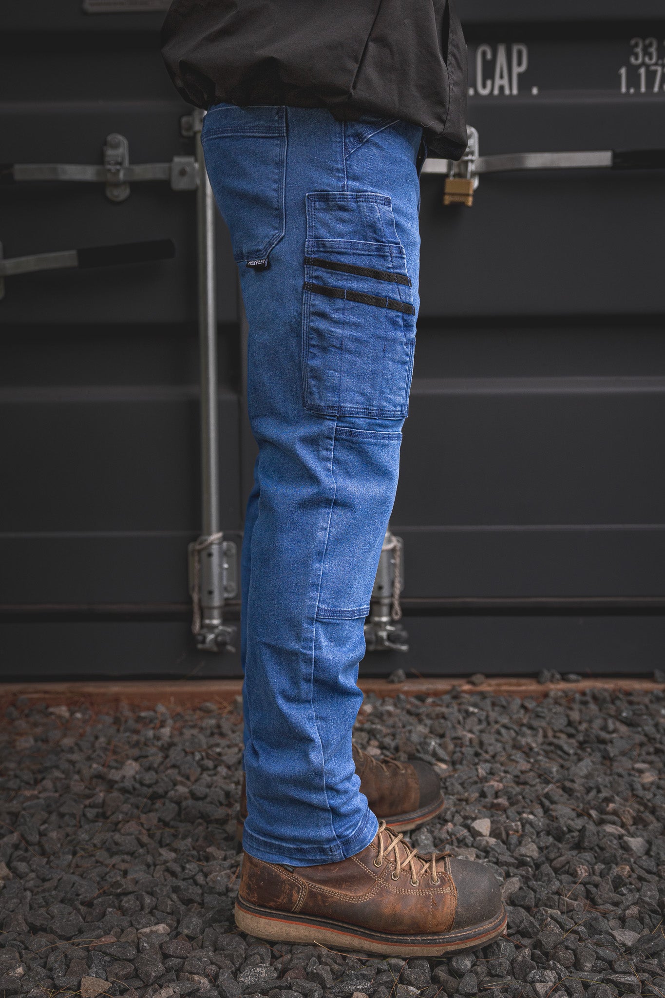 
                  
                    Side angle of the RX-1 Relaxed Work Jeans in Stonewashed Blue, highlighting the multi-function utility pocket layout and stretch fit—made for jobsite toughness and everyday comfort.
                  
                