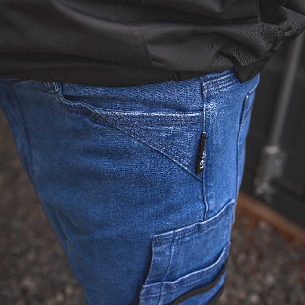 
                  
                    RX-1 Relaxed Work Jeans in Stonewashed Blue shown in close-up, highlighting the reinforced angled pocket design and woven Huxtley tag—built for everyday grind and jobsite hustle.
                  
                